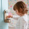 Enfant déposant une dent de lait dans la boîte suspendue Fée des dents accrochée à une porte