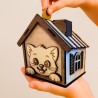 Enfant insérant une pièce dans la tirelire maison chat en bois – apprentissage de l’épargne