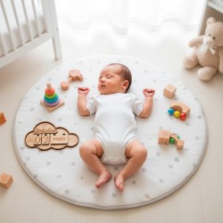 Bébé couché sur un tapis d’éveil avec la pancarte nuage évolutive personnalisée Antoine 3 mois