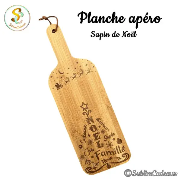 Planche apéro en bambou en forme de bouteille, gravée d'un décor de Noël avec traîneau du Père Noël et mots de fête