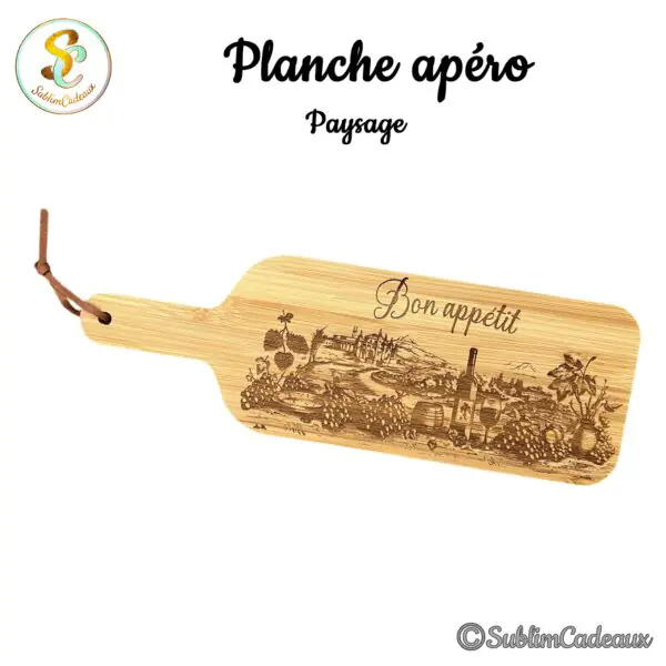 Planche apéro en bambou avec lanière de cuir, gravée d'un paysage viticole avec vignes, château et bouteille de vin