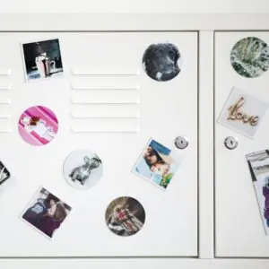 Magnets photo ronds et carrés aimantés sur un meuble métallique blanc, images variées dont un chien et un couple