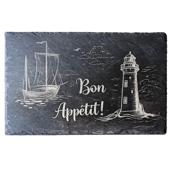 Ardoise noire gravée d'un voilier et d'un phare en bord de mer avec la mention Bon Appétit