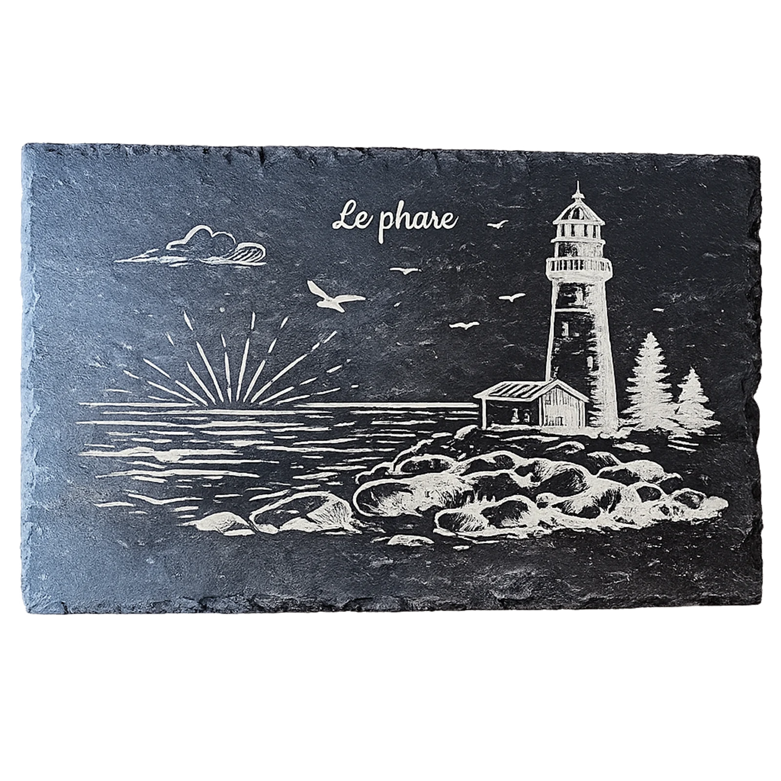 Ardoise noire gravée d'un phare sur les rochers au coucher de soleil, avec maisonnette et sapins