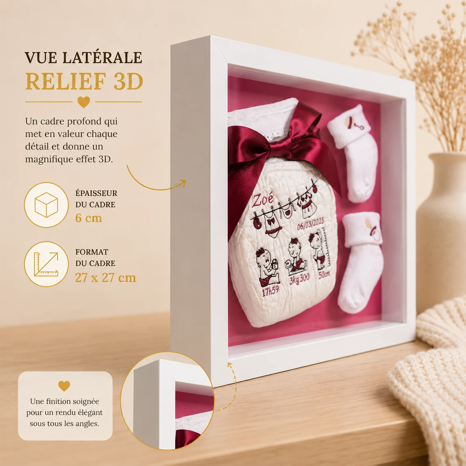 Vue latérale du cadre naissance fille en relief, couche brodée au prénom Zoé et chaussons sur fond rose framboise
